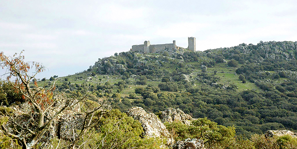 Imagen de un paisaje donde se divisa en el horizonte la silueta de un castillo